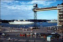 M/S Kungsholm för ankar utanför Slussen. Katarinahissen i förgrunden. Vy från Slussen