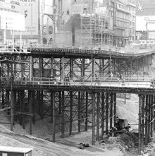 Vy mot kv. Åskslaget under pågående rivning. I förgrunden provisoriska broar för fotgängare och trafik