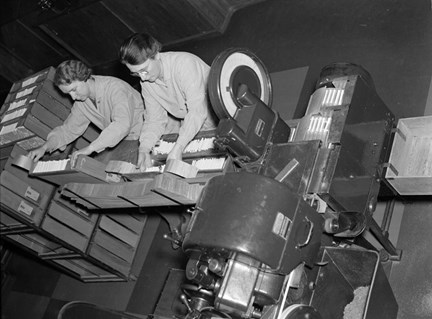Två personer hanterar cigaretter i fabrik.