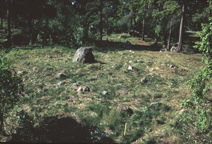 Den ännu inte avtorvade stensättningen med mittstenen centralt i graven.  