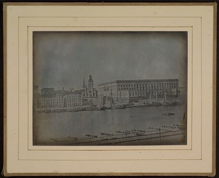 Kungliga Slottet och Storkyrkan sett från Skeppsholmen, tvärs över vattnet.