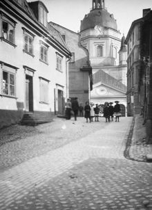 Katarina Kyrkobacke söderut mot Katarina kyrka. En grupp barn står på Katarina Kyrkobacke vid Lilla Fiskaregränd (nuv. Roddargatan)