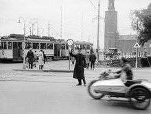 Trafikpolis dirigerar trafiken vid Tegelbacken. I fonden Stadshuset.