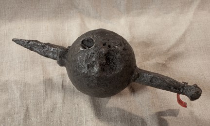 Medeltida piklod till kanon. Fotograferat mot grålila bakgrund.