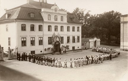 Svartvitt fotografi på barn som står uppställda på gården utanför Frimurarbarnhuset