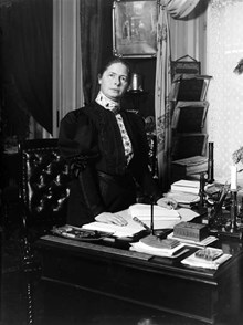 Porträtt av medicine doktor Karolina Widerström vid ett skrivbord.