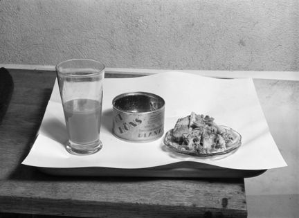 Glas med dryck, onservburk, fat med kött.