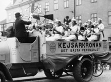 Musikframträdande på Barnens dag. En blåsorkester sitter på ett lastbilsflak, som gör reklam för Kejsarkronans vetemjöl