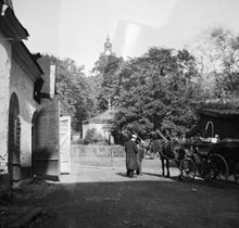 Gårdssidan vid Hantverkargatan 9. Två män står vid ett hästfordon. I fonden ses tornet på Kungsholms kyrka. Fastigheten ägdes av Nya Murbruksfabriken AB. Då kv. Bryggaren, nu kv. Munklägret