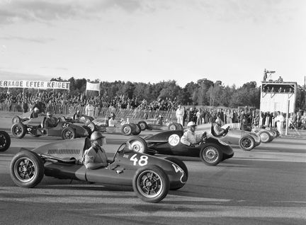 Motortävlingen "Skarpnäcksloppet". Bilar står uppradade vid startlinjen. i bakgrunden en stor publik